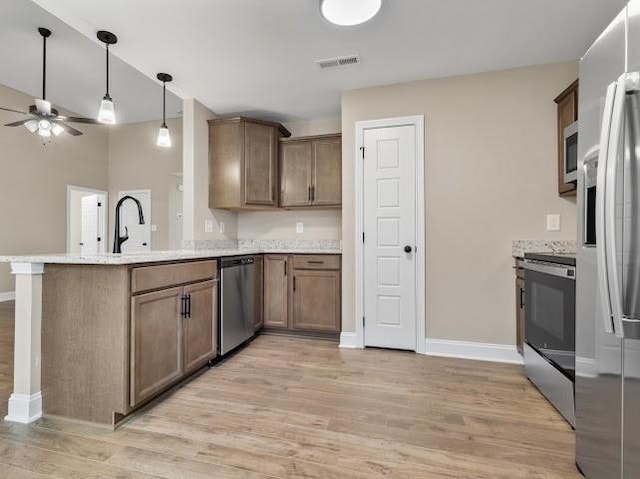 kitchen with ceiling fan, appliances with stainless steel finishes, kitchen peninsula, and light hardwood / wood-style flooring