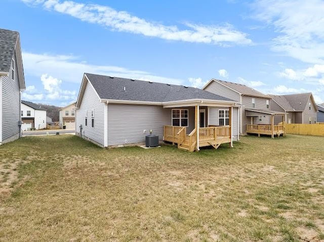 back of house featuring cooling unit, a yard, and a deck