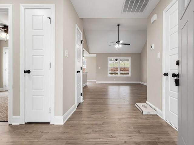 foyer entrance featuring wood-type flooring, ceiling fan, and vaulted ceiling