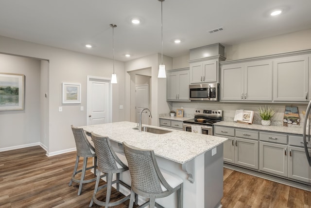 kitchen with dark hardwood / wood-style flooring, stainless steel appliances, sink, and decorative light fixtures