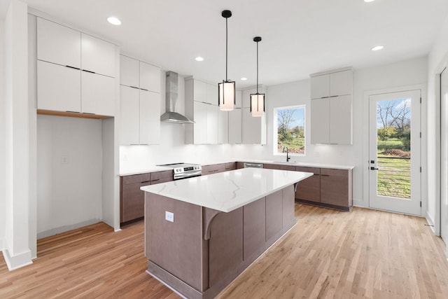 1016 W Trinity Ln Unit 1, Nashville, TN 37218 - kitchen with wall chimney range hood, a center island, light wood-style flooring, modern cabinets, and stainless steel appliances