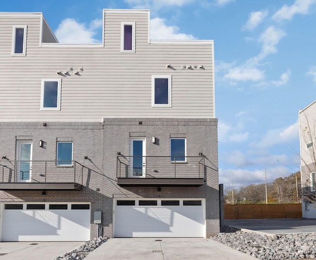 back of property with a balcony and a garage