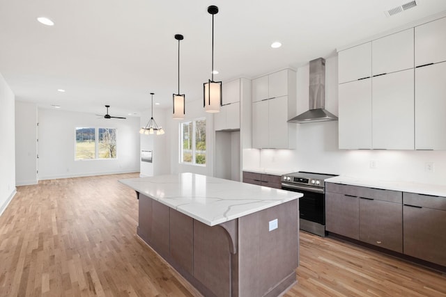 kitchen featuring white cabinetry, electric range, wall chimney exhaust hood, and light hardwood / wood-style floors