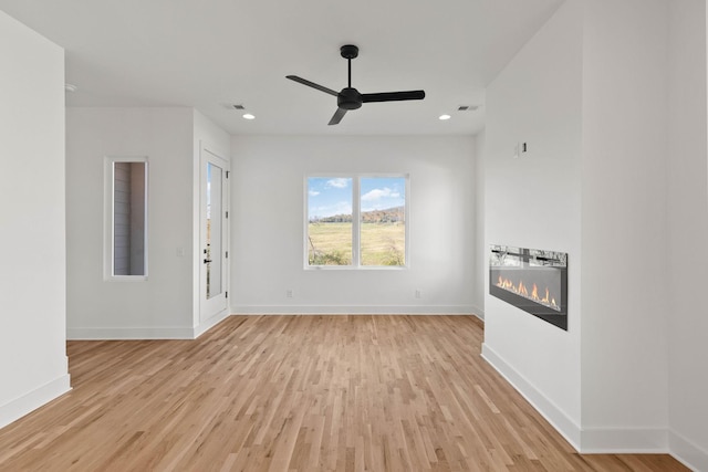 unfurnished living room with ceiling fan and light hardwood / wood-style flooring