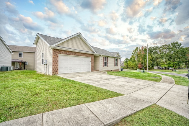 view of front of home featuring a garage, central air condition unit, and a front yard