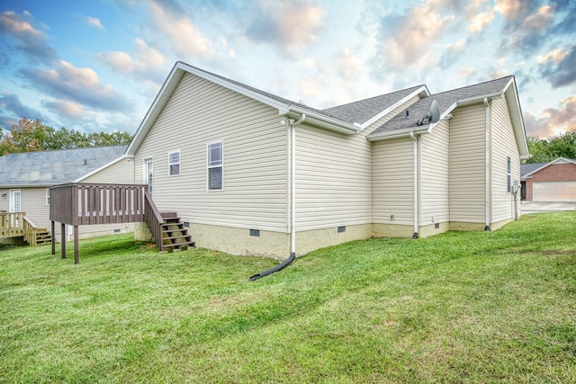 rear view of house featuring a deck and a lawn