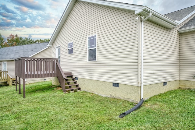 view of home's exterior featuring a wooden deck and a lawn