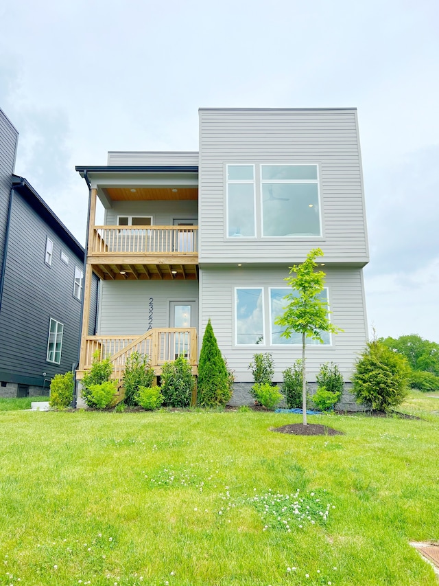 back of house with a balcony and a lawn