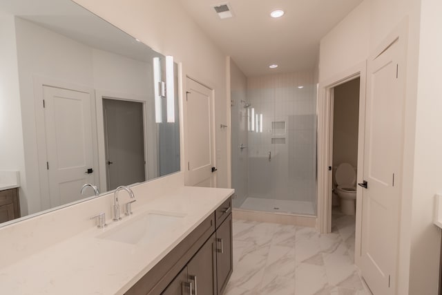 bathroom with vanity, a shower with door, and toilet