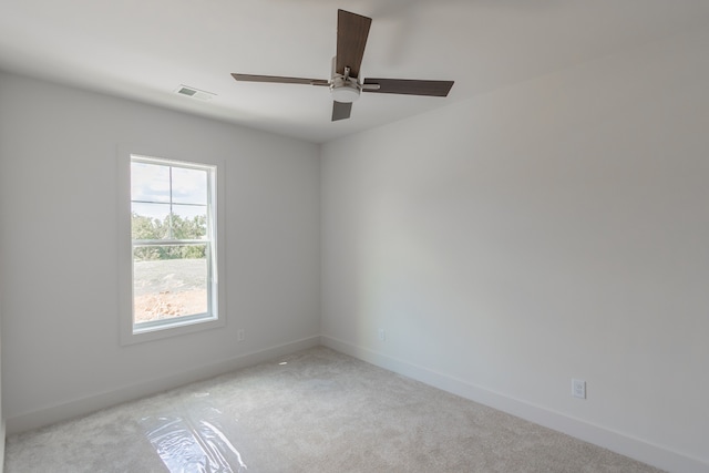 carpeted spare room with ceiling fan