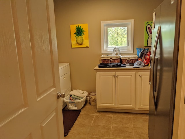 clothes washing area with light tile floors