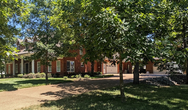 obstructed view of property with a garage and a front yard