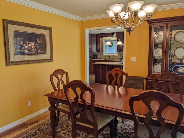 dining room with a notable chandelier, ornamental molding, and hardwood / wood-style flooring