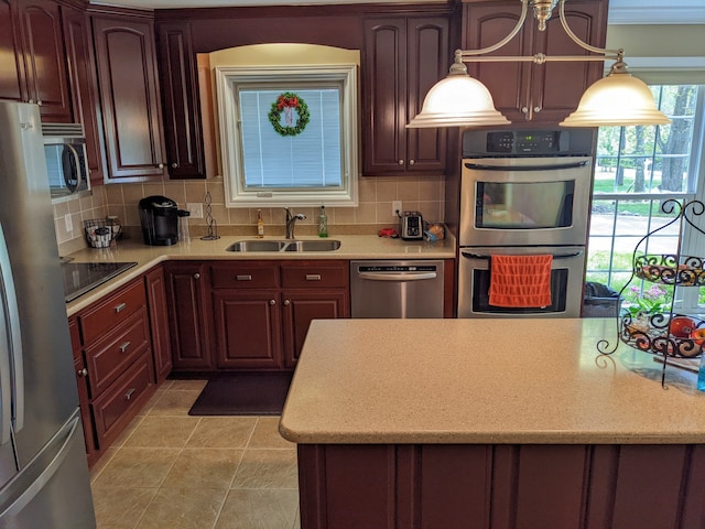 kitchen with stainless steel appliances, decorative light fixtures, backsplash, light tile floors, and sink