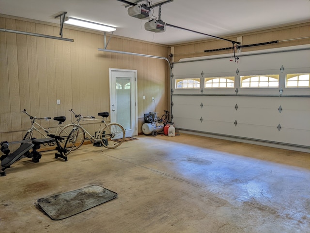 garage featuring a garage door opener and wooden walls