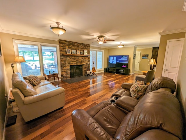 living room featuring crown molding, ceiling fan, a fireplace, and wood-type flooring