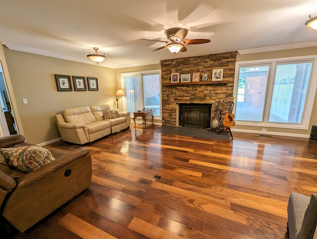 living room featuring crown molding, plenty of natural light, a fireplace, and hardwood / wood-style flooring