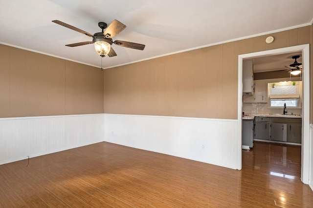 spare room with crown molding, wood-type flooring, and sink