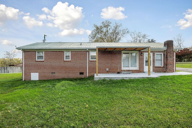 back of house featuring a lawn and a patio area