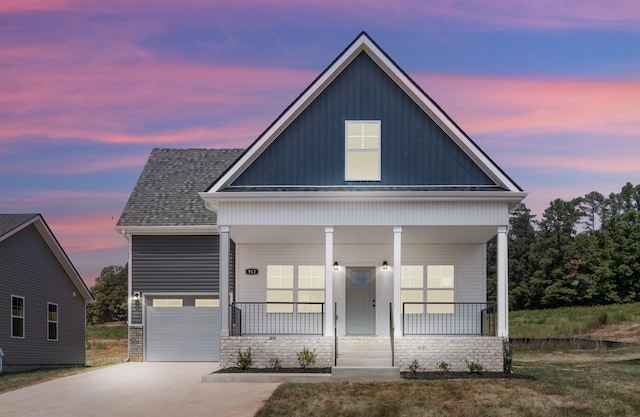 view of front of house featuring covered porch, a garage, concrete driveway, roof with shingles, and board and batten siding