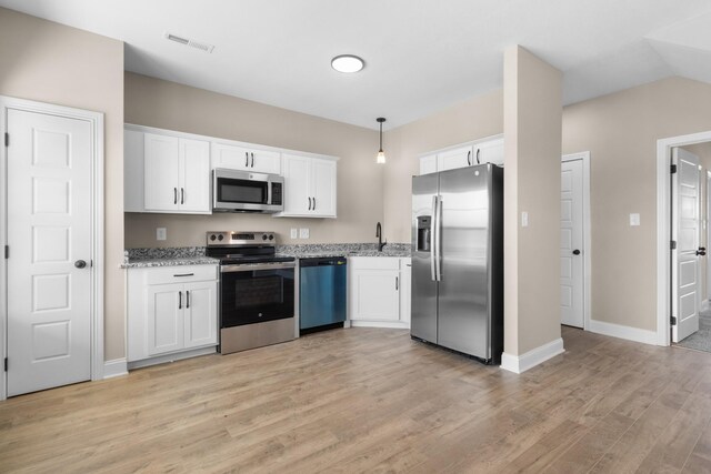 kitchen featuring stainless steel appliances, decorative light fixtures, light wood-type flooring, and white cabinetry