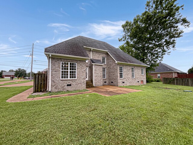 rear view of house featuring a yard and a patio