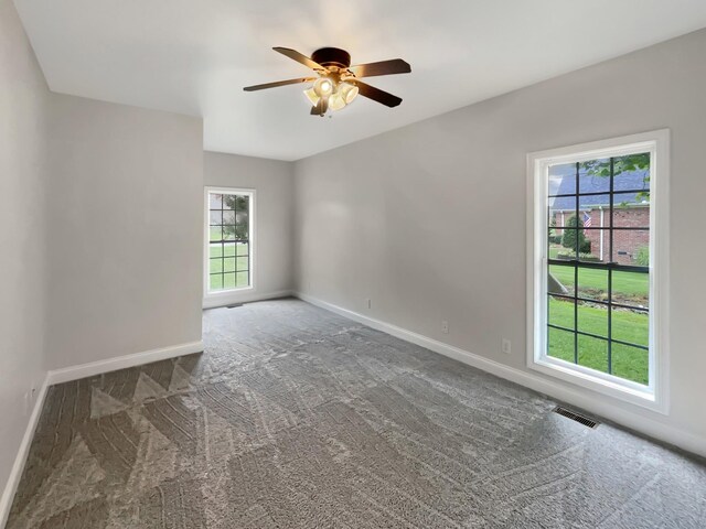 carpeted spare room featuring ceiling fan