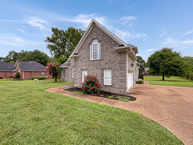 view of side of property with a yard and a garage