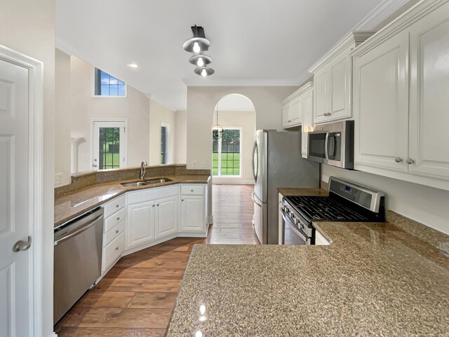 kitchen with kitchen peninsula, white cabinets, sink, and stainless steel appliances