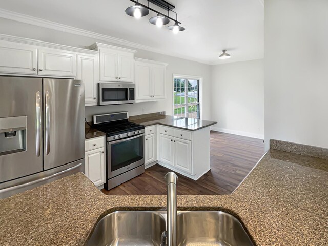 kitchen featuring white cabinets, kitchen peninsula, appliances with stainless steel finishes, and sink