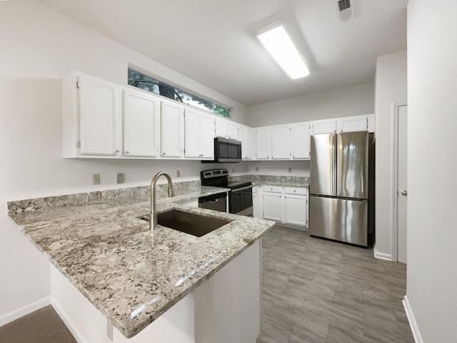 824 N Woodstone Ln, Nashville, TN 37211 - kitchen featuring appliances with stainless steel finishes, a sink, a peninsula, light stone counters, and baseboards
