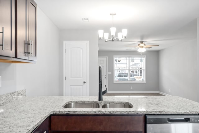 kitchen with light stone counters, sink, stainless steel dishwasher, and dark brown cabinetry