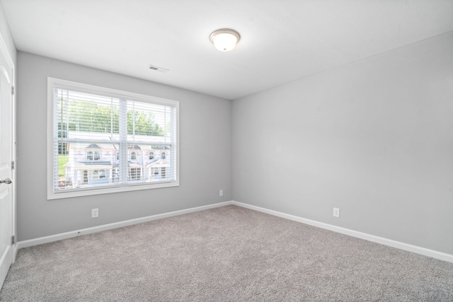 carpeted empty room with baseboards and visible vents