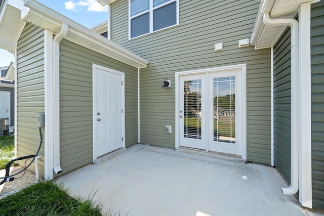 view of exterior entry with a patio area