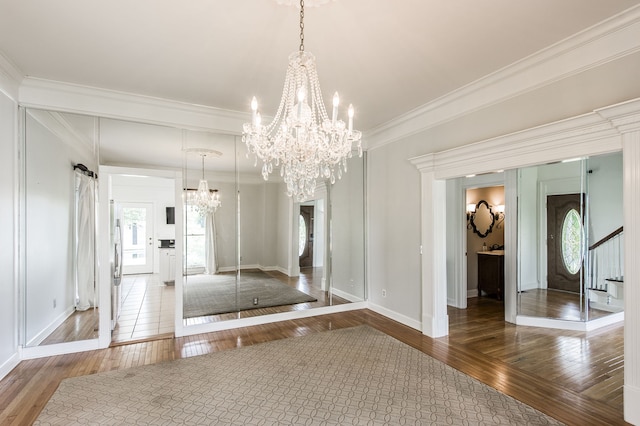 unfurnished dining area featuring ornamental molding, a barn door, and hardwood / wood-style floors