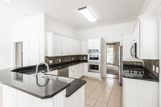 kitchen with appliances with stainless steel finishes, kitchen peninsula, light tile patterned floors, and white cabinets