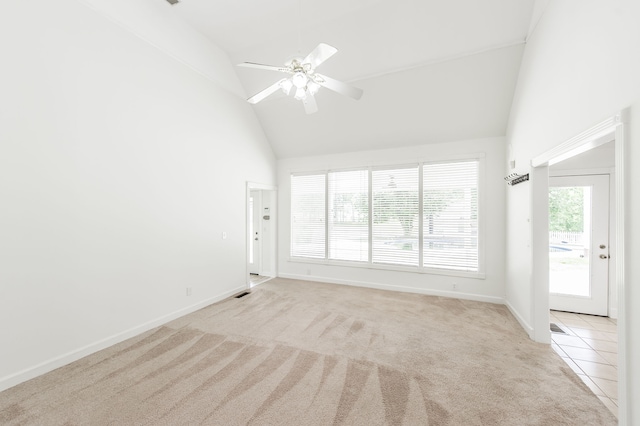 carpeted spare room with ceiling fan and high vaulted ceiling