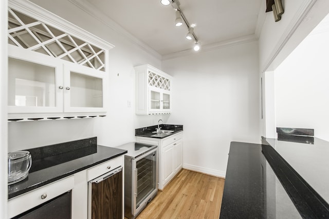 kitchen featuring sink, light hardwood / wood-style flooring, ornamental molding, beverage cooler, and white cabinets