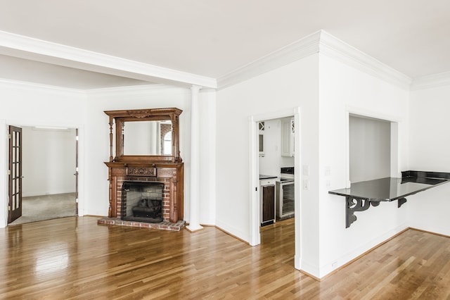 unfurnished living room featuring a brick fireplace, crown molding, and wood-type flooring