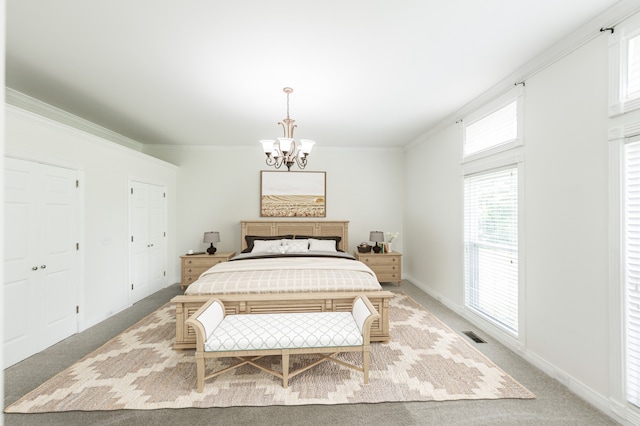 carpeted bedroom featuring crown molding and a chandelier