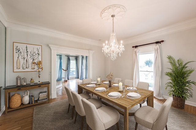 dining area featuring crown molding, dark hardwood / wood-style floors, and a chandelier