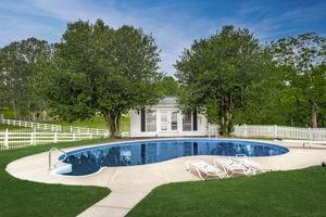 view of swimming pool featuring a yard, an outdoor structure, and a patio