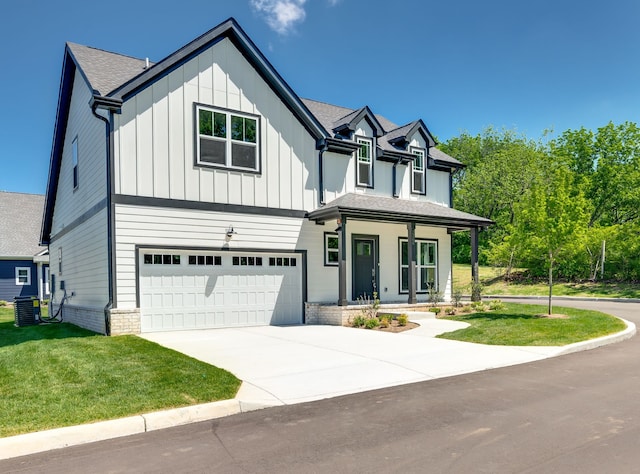 view of front facade featuring a garage, central AC unit, and a front yard