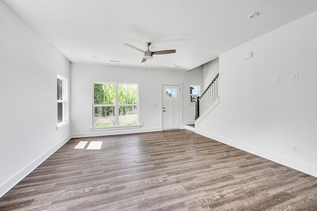 unfurnished living room featuring dark hardwood / wood-style flooring and ceiling fan