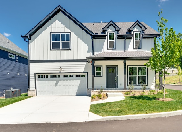 view of front facade with a garage, central AC unit, and a front yard