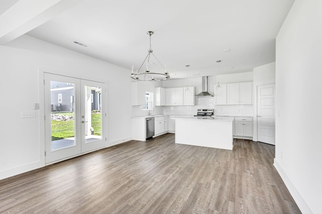 kitchen with white cabinets, dark hardwood / wood-style floors, stainless steel appliances, and wall chimney exhaust hood