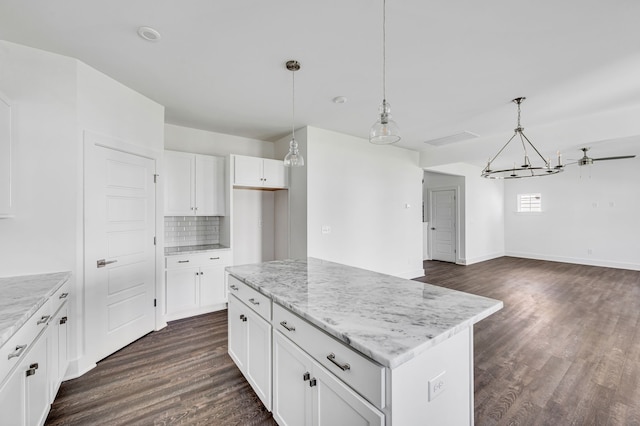 kitchen with backsplash, dark hardwood / wood-style floors, white cabinets, pendant lighting, and a center island