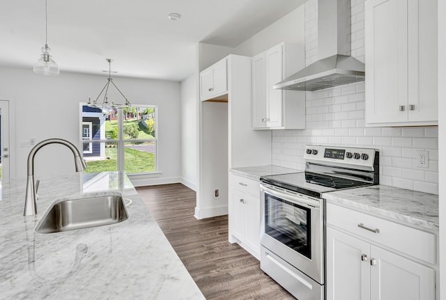 kitchen with stainless steel range with electric cooktop, hanging light fixtures, dark hardwood / wood-style floors, tasteful backsplash, and wall chimney exhaust hood