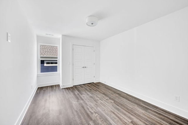 unfurnished bedroom with dark hardwood / wood-style flooring and a closet