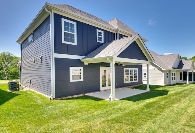 back of property with a patio area, french doors, a yard, and central AC